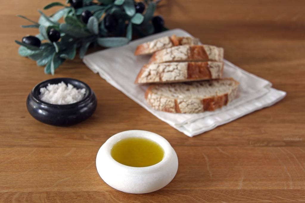 Koroneiki-Olivenöl-Test: Neben Brot und Salz steht eine kleine Schale mit Olivenöl. 