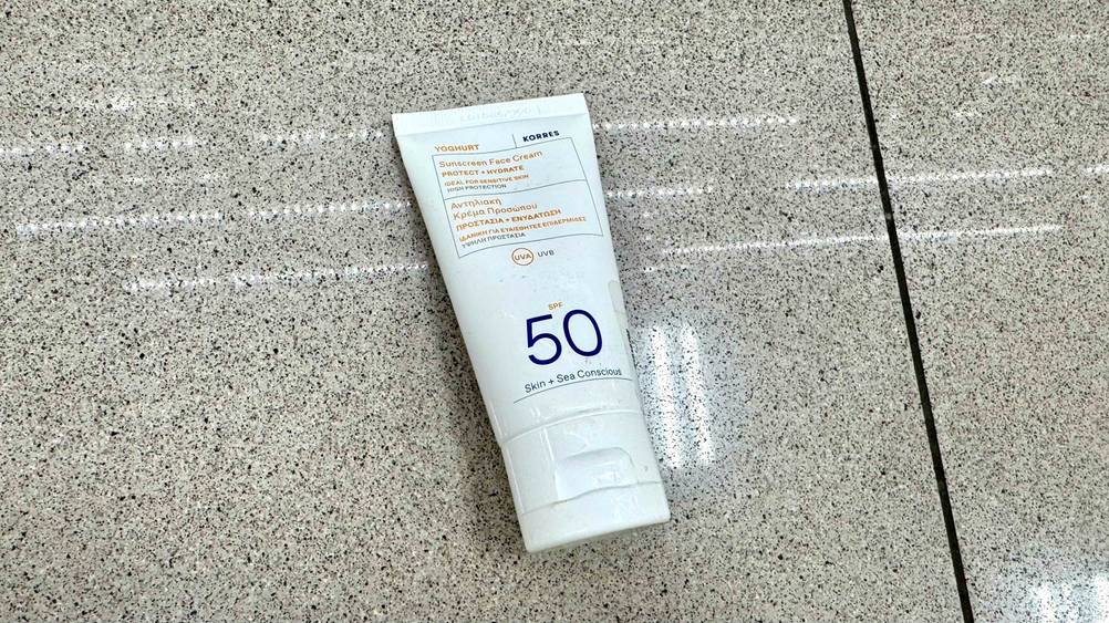 Auf einem Fließenboden liegt eine Tube der Korres-Sonnencreme im Test.