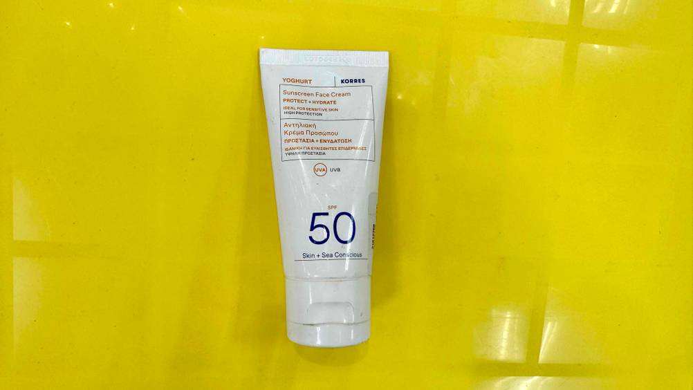 Auf einem gelben Untergrund liegt eine Tube der Korres-Sonnencreme im Test.