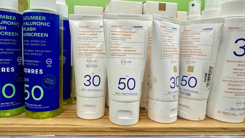 Mehrere Tuben der getesteten Korres-Sonnencreme stehen in einem Verkaufsregal neben anderen Produkten.
