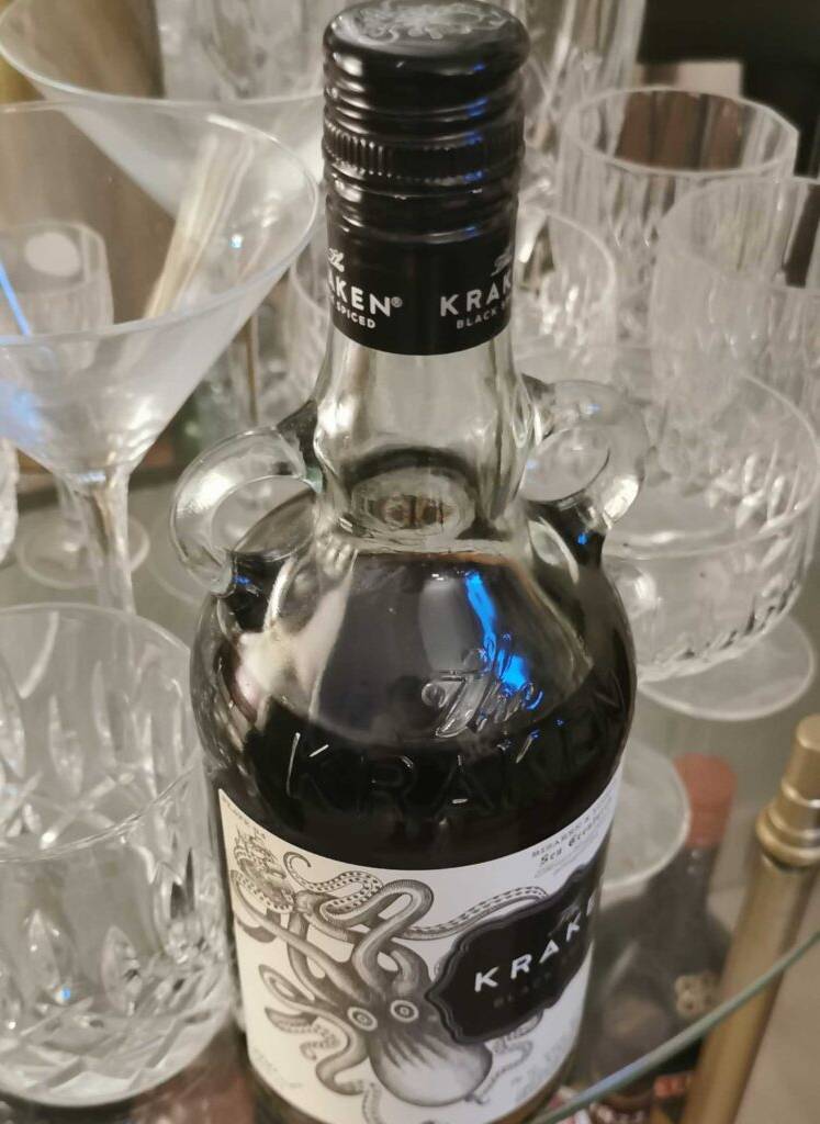 Rum-Test: Ansicht von oben auf eine Flasche Kraken-Rum neben mehreren Kristallgläsern auf einem Glastisch.
