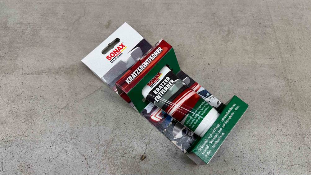 Auf einem Betonboden liegt eine Packung des getesteten Kratzer-Entferners.