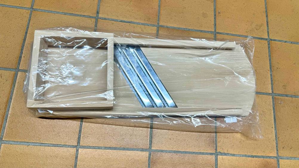 Rückseite eines verpackten Krauthobels auf einem Fließenboden.