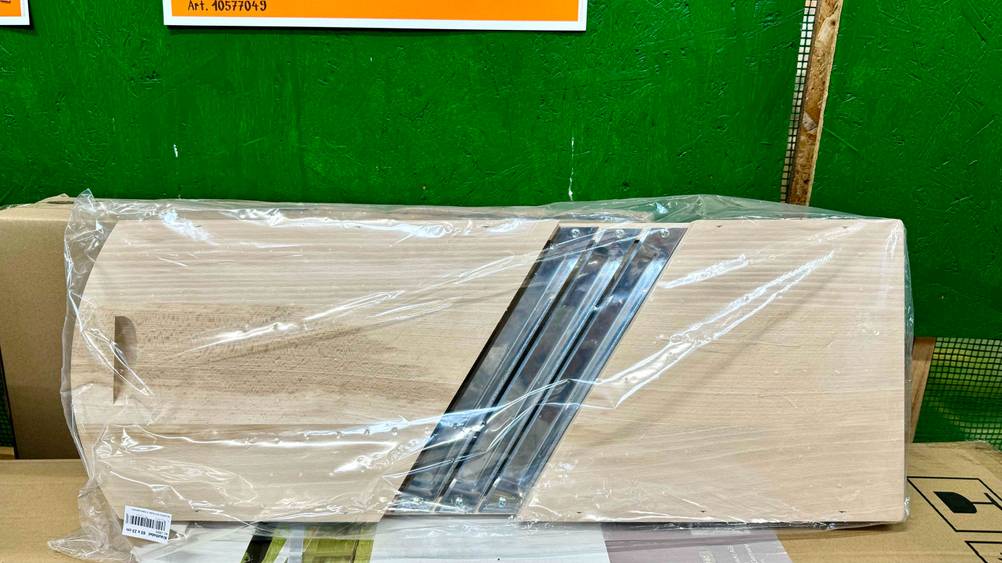 Krauthobel getestet: Ein transparent verpacktes Produkt vor einer grünen Wand.
