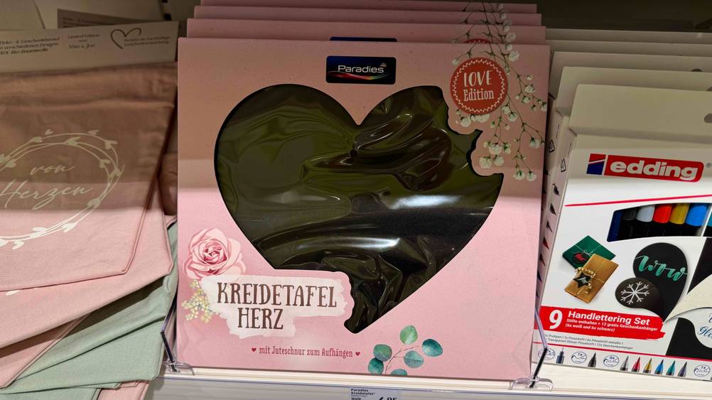 Mehrere verpackte Kreidetafeln im Test in einem Verkaufsregal neben anderen Produkten.