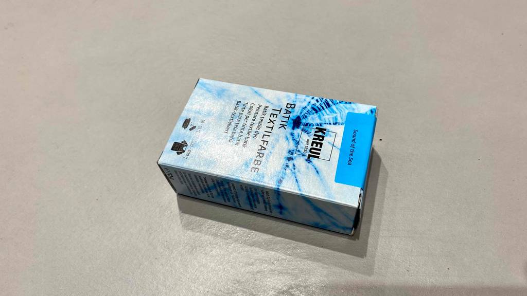 Batikfarben-Test: Verpackung mit Batikfarben liegt auf grauem Boden.