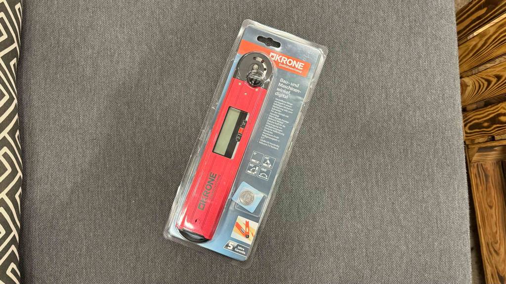 Digitaler Winkelmesser im Test: Ein verpacktes Gerät liegt auf einem Steinboden.