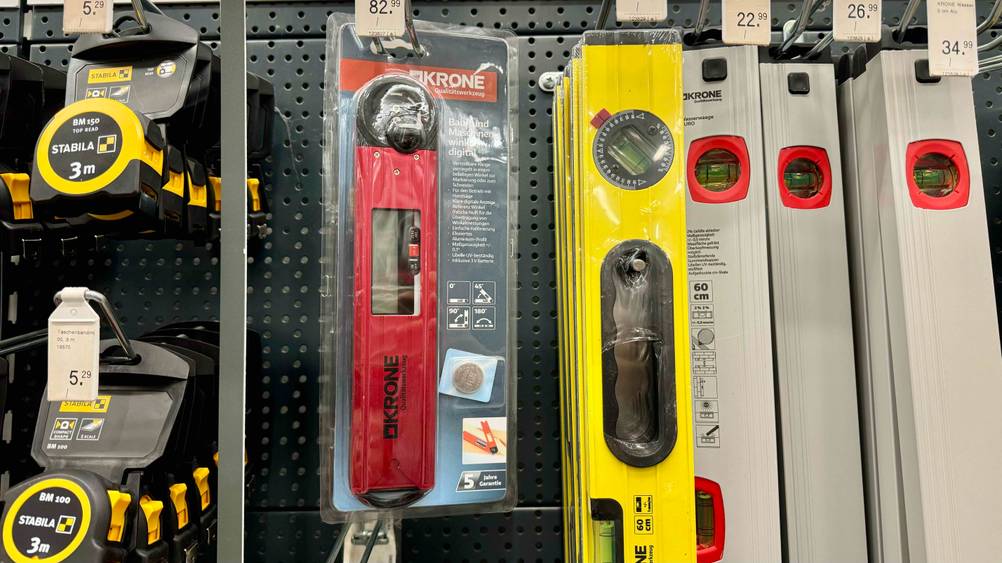 Mehrere getestete digitale Winkelmesser hängen zwischen anderen Produkten in einem Regal.