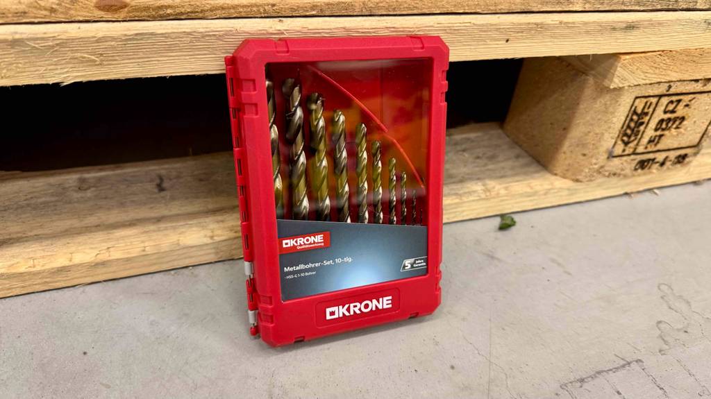 Getestet: Mehrere Metallbohrer stehen zusammen in einer roten Box vor einer Palette.