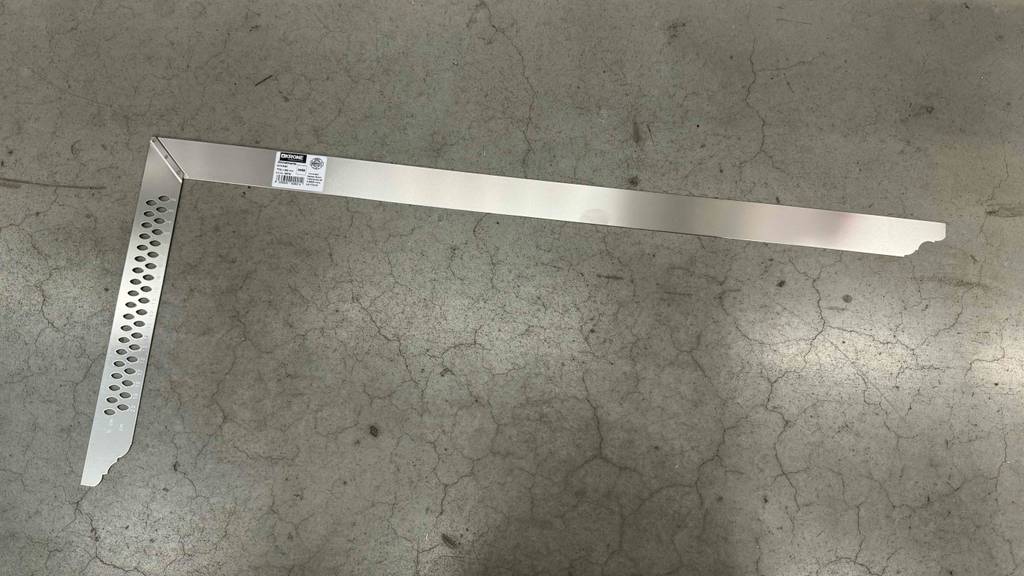 Ein Zimmermannswinkel liegt getestet auf einem Betonboden.