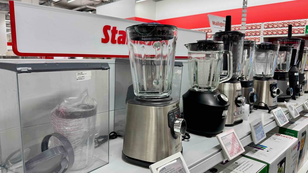 Im Test: Ein Krups-Standmixer steht zwischen mehreren anderen Geräten auf einem weißen Regal.