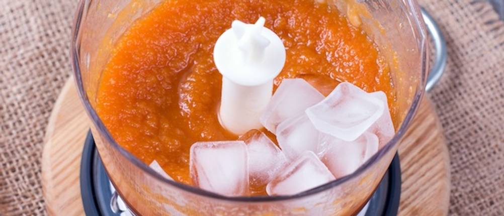 Krups-Standmixer getestet: Ein Blick von oben in einen Mixbehälter mit orangefarbenem Smoothie und Eiswürfeln.
