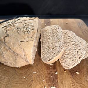 Geschnittenes Brot aus dem Krustenzauber-Gusseisen-Topf liegt auf einem Holzbrett