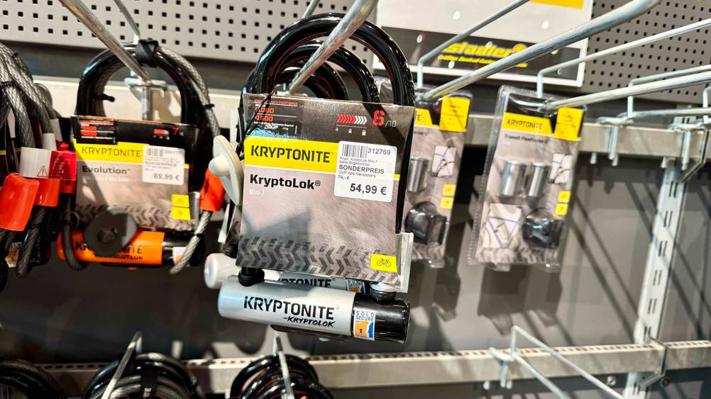 Mehrere des Kryptonite-Bügelschloss im Test hängen in einem Verkaufsregal.