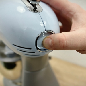 Nahaufnahme, wie die Arretierung des Maschinenarms gelöst wird.