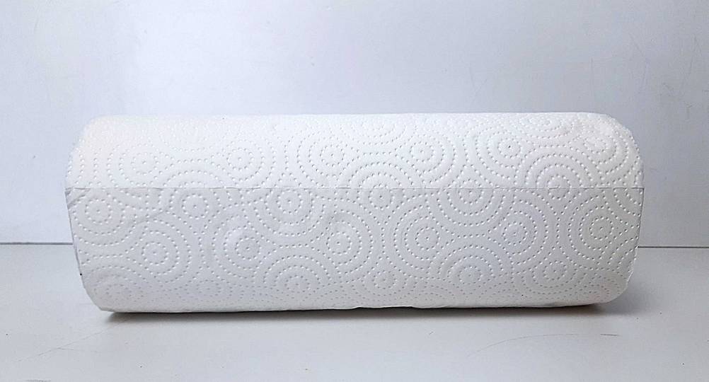Eine getestete Küchenrolle horizontal auf einer hellen Fläche liegend.