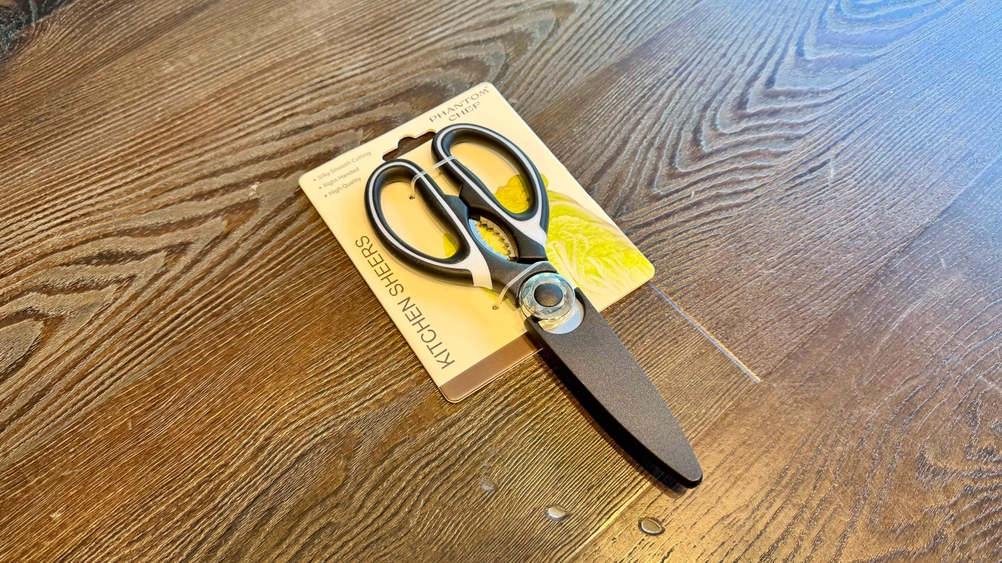 Auf einer Holzfläche liegt eine Küchenschere im Test.