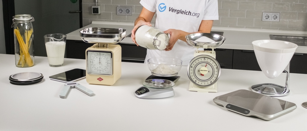 Verschiedene Küchenwaagen, eine Waage wird gerade mit Mehl gefüllt