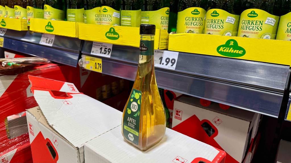 Eine Flasche Bio-Essig steht zum Testen auf einem Karton vor einem Verkaufsregal.