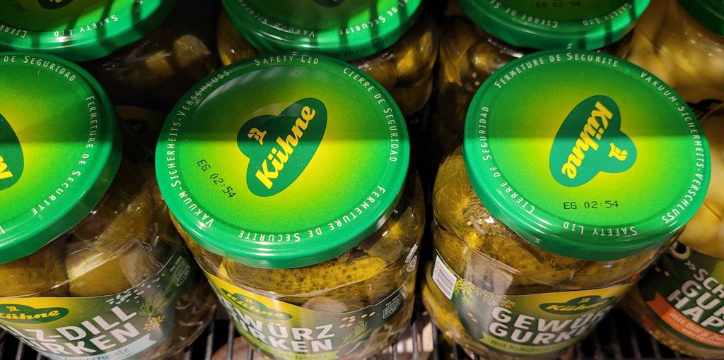 Auf den Deckeln von mehreren Gläsern Gewürzgurken im Test ist der Herstellername aufgedruckt.