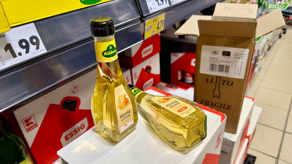Getestet: Eine Flasche Honig-Essig liegt neben einer stehenden auf einem Karton.