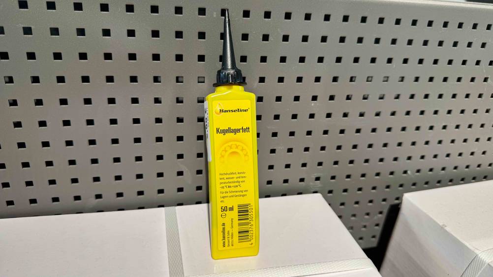Das Kugellagerfett im Test vor einer grauen Wand auf einem weißen Karton.