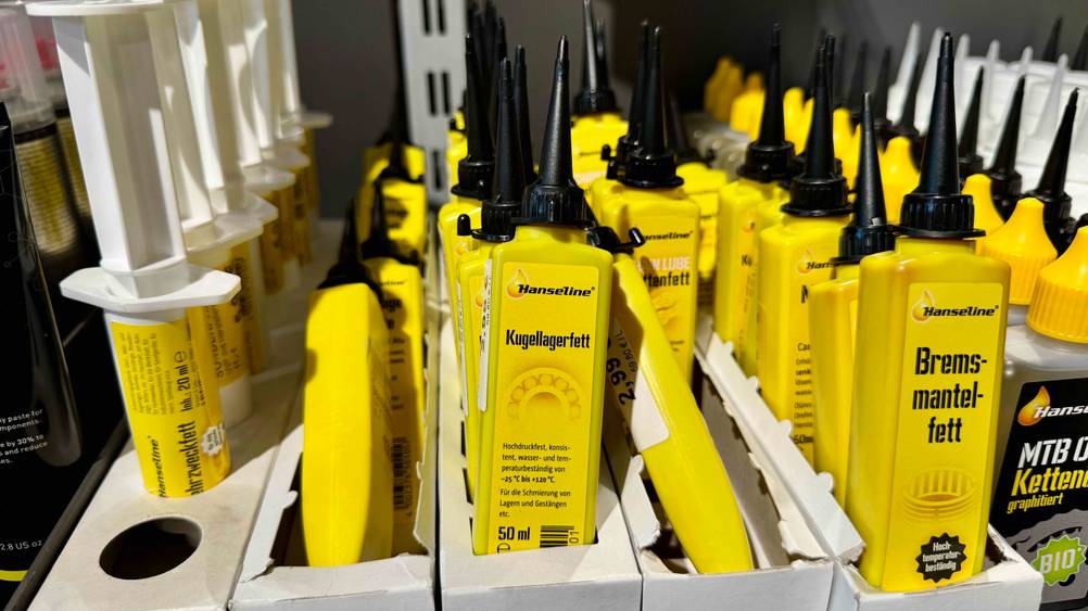 Mehrere Tuben des getesteten Kugellagerfetts in einem Verkaufsregal neben anderen Produkten.