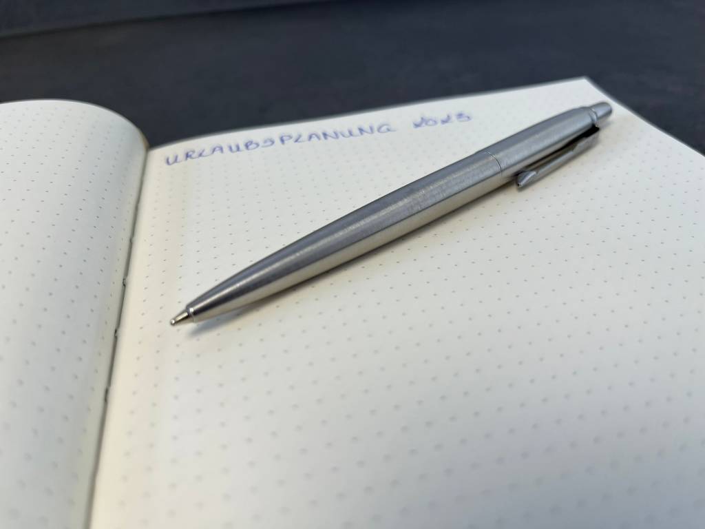 Kugelschreiber auf einem Notizbuch mit einer Notiz.