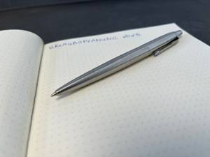 Kugelschreiber auf einem Notizbuch mit einer Notiz.