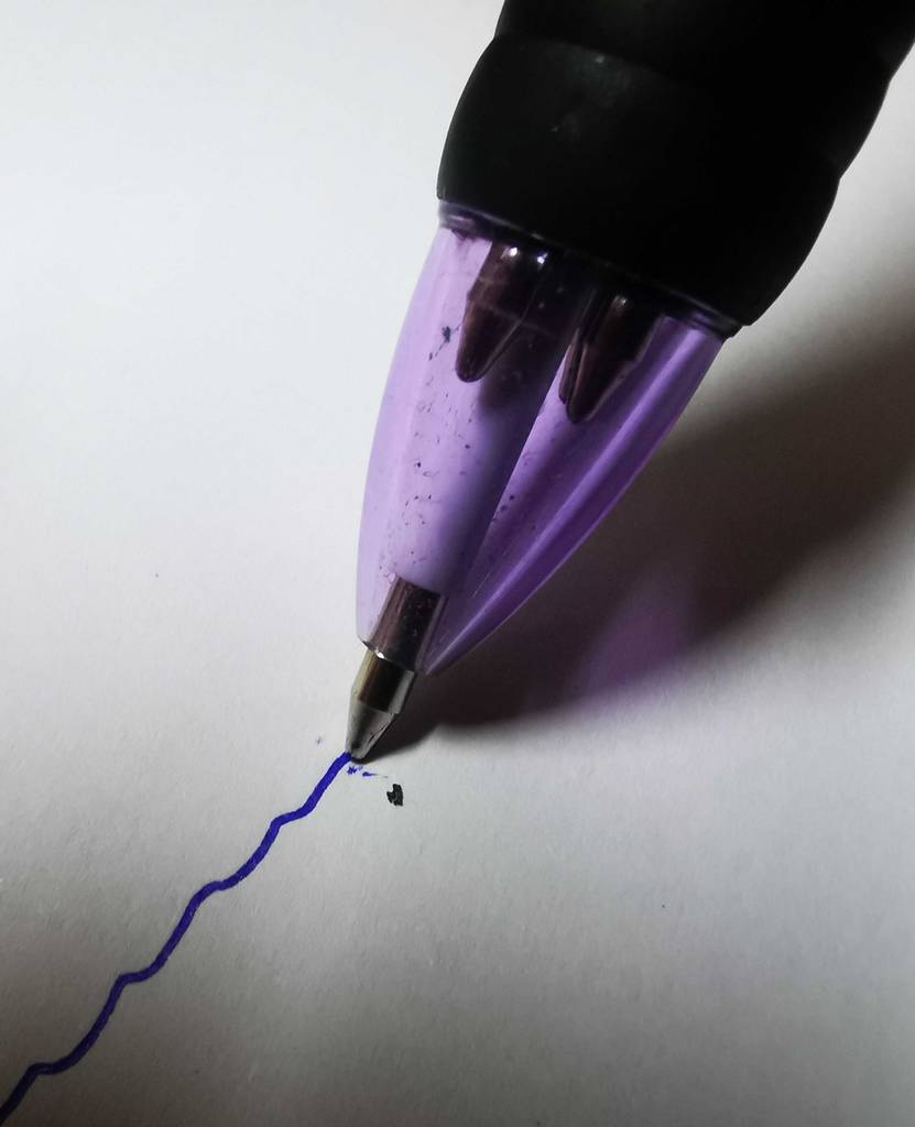 Eine Kugelschreibermine im Test zieht eine Linie auf einem Papier.