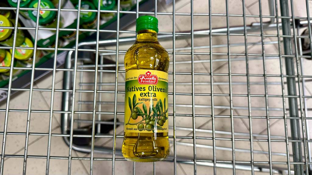 Das kaltgepresste Öl im Test besteht aus Oliven und liegt in einem Einkaufskorb.