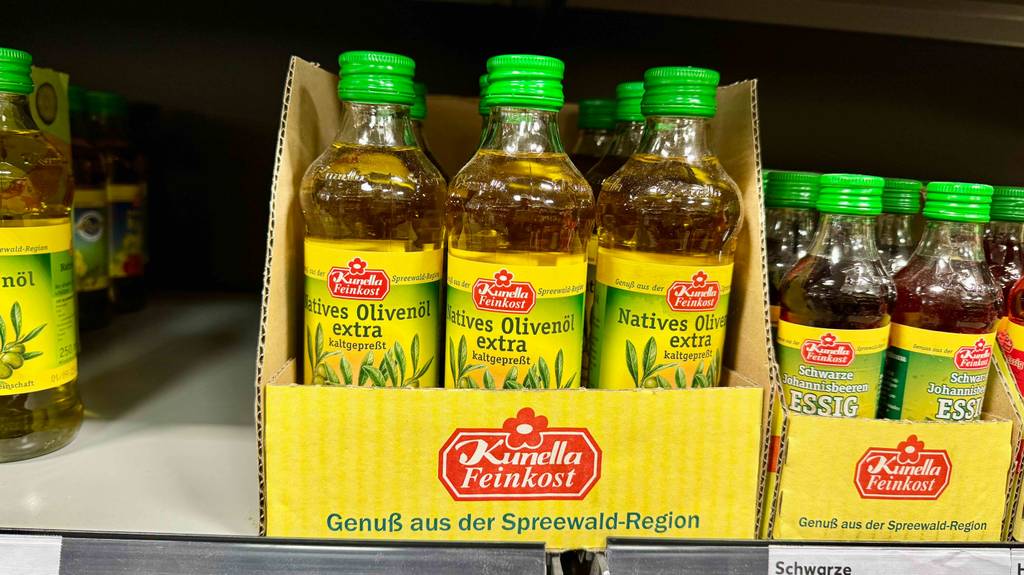 Das getestete kaltgepresste Öl aus Oliven steht in mehreren Flaschen nebeneinander auf einem Verkaufsregal im Supermarkt.