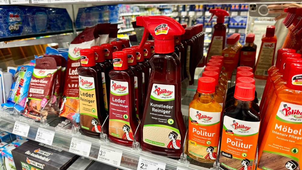 Mehrere Flaschen der Kunstleder-Pflege im Test in einem Verkaufsregal neben anderen Produkten.