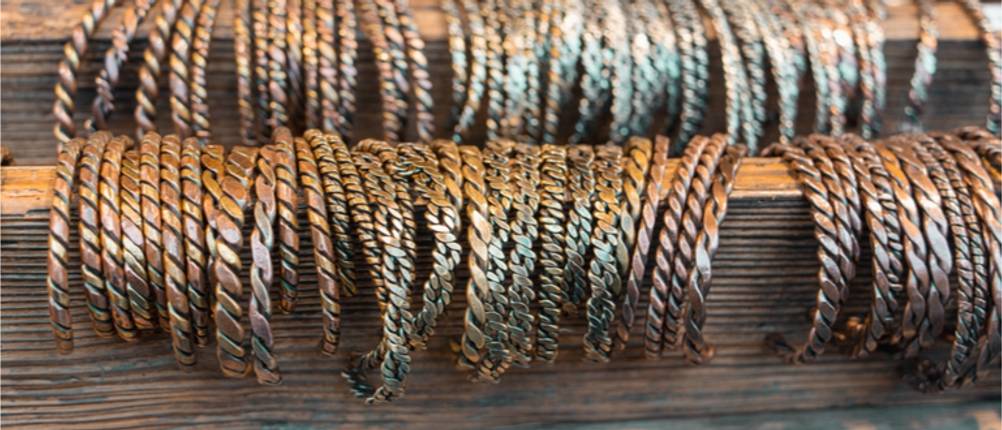 Kupferarmband-Test: viele handgemachte Kupferarmbänder in einer Reihe.