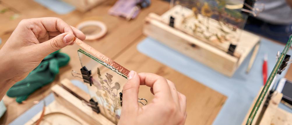 Kupferband-Test: Frau klebt Kupferband auf Herbarium aus Glas