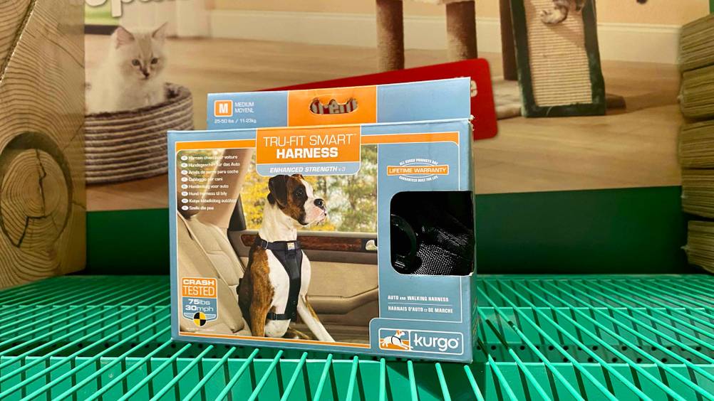 Im Test: Ein originalverpacktes Sicherheitsgeschirr für den Hund von schräg vorne auf einem grünen Gitter.