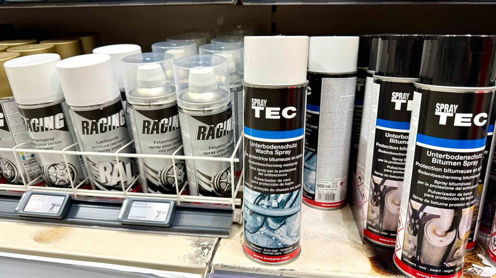 Unterbodenwachs im Test: Mehrere Dosen stehen zwischen anderen Produkten in einem Regal.