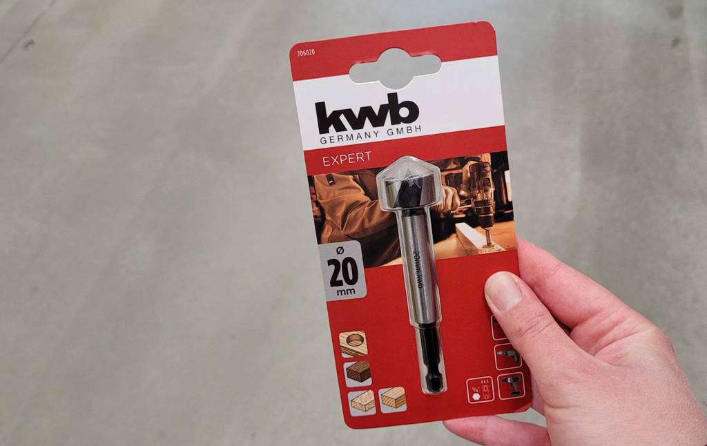 Eine Hand hält eine Packung mit einem Forsterbohrer 20 mm zum testen.