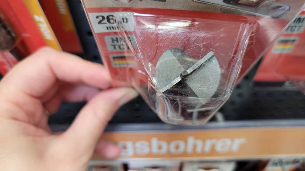 Scharnierbohrer im Test: Hand hält Verpackung hoch. 