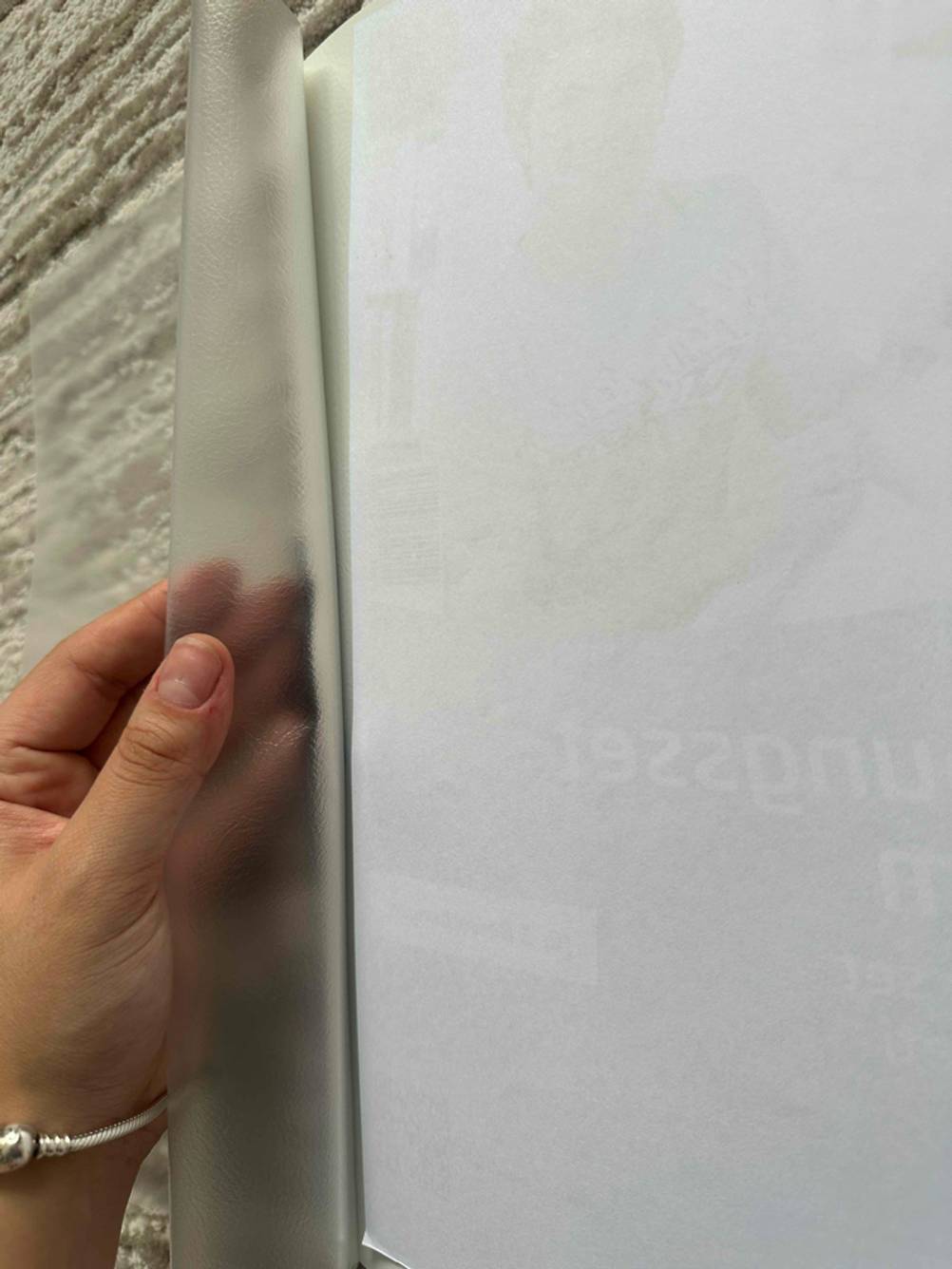 Hand öffnet das transparente Deckblatt einer weißen Bewerbungsmappe im Test.