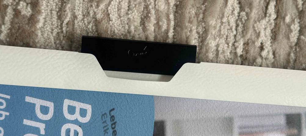 Detailansicht einer schwarzen, schwenkbaren Klemme einer weißen getesteten Bewerbungsmappe inklusive blauem Deckblatt.