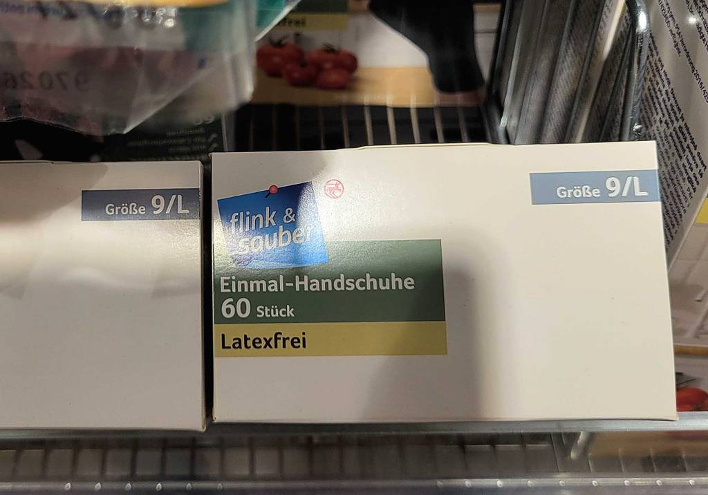 Eine Packung mit Einmalhandschuhen-L im Test steht in einem Regal.