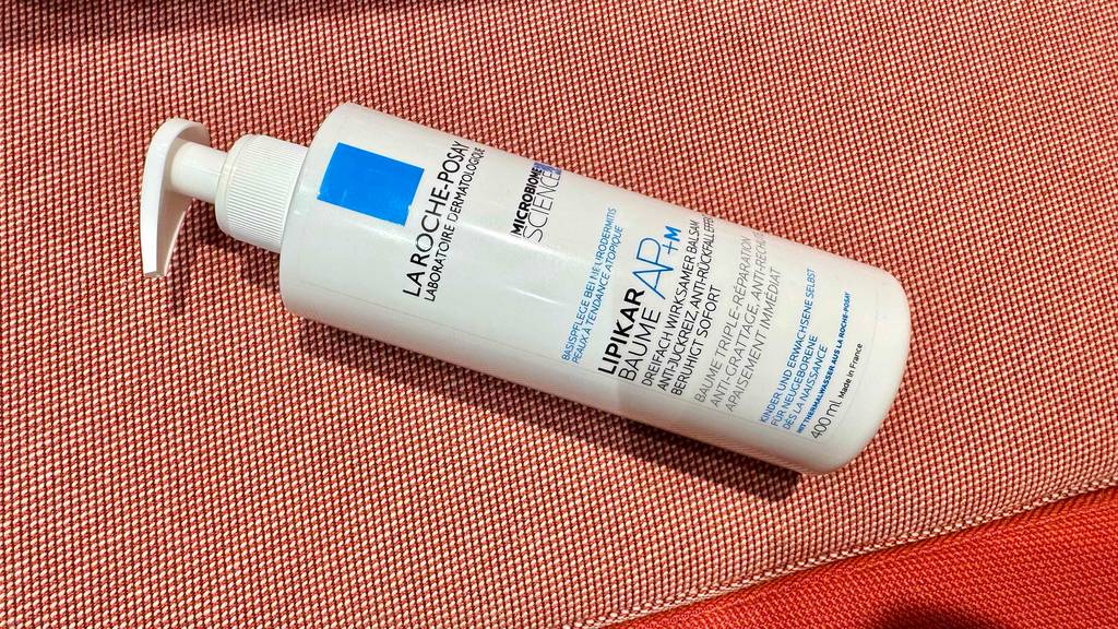 Im Test: Eine Flasche La Roche Posay Bodylotion liegt auf einem roten Tuch.