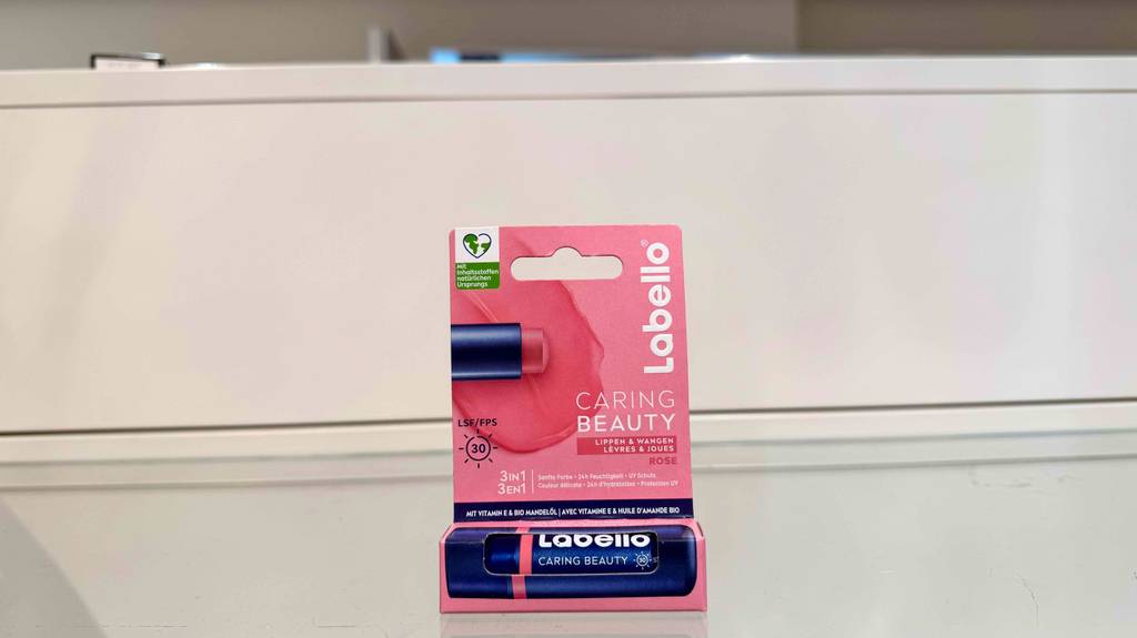Getestet: Lippenpflege mit Farbe steht in der Verpackung auf einem Glasregal.