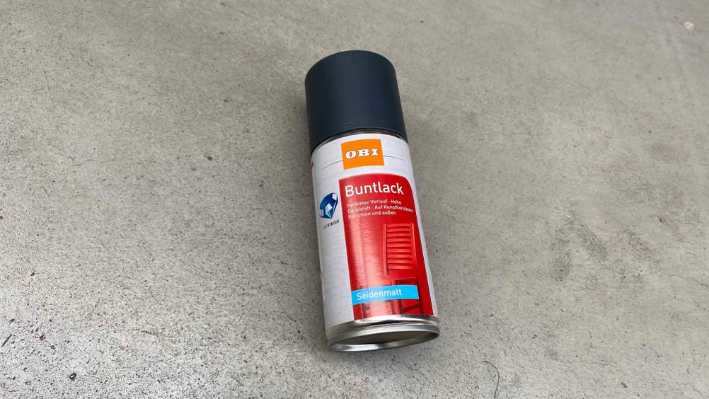 Auf dem Boden liegt eine Flasche getestetes Lackspray.