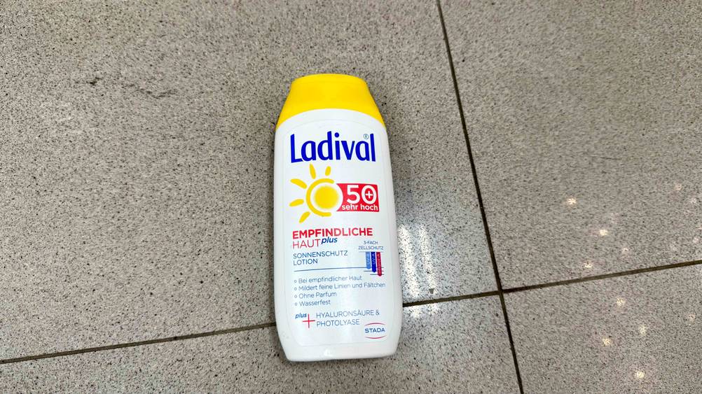 Auf einem Fließenboden liegt die getestete Ladival-Sonnencreme.