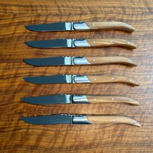 Sechs Laguiole-Style-de-Vie-Steakmesser Luxury Line liegen übereinander auf einem Tisch