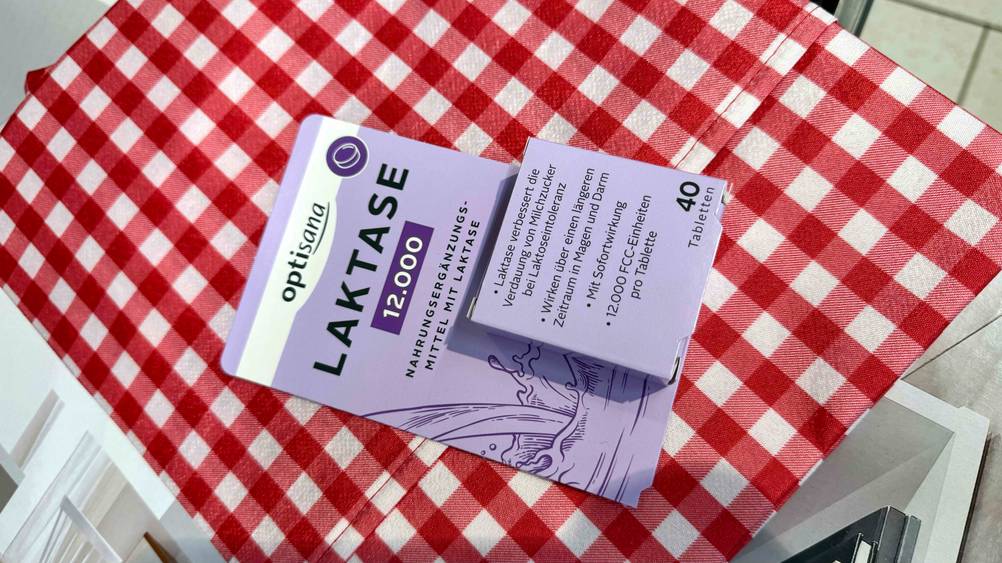 Getestet: Eine Packung Laktase-Tabletten liegt auf einer rot-weiß karierten Decke.