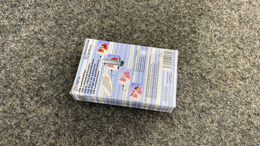 Die Rückseite einer Packung der getsteten Laminierfolien auf einem grauen Teppich.