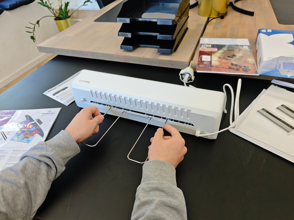 Ein Auffanggitter wird an das Laminiergerät Fellowes Saturn 3i montiert.